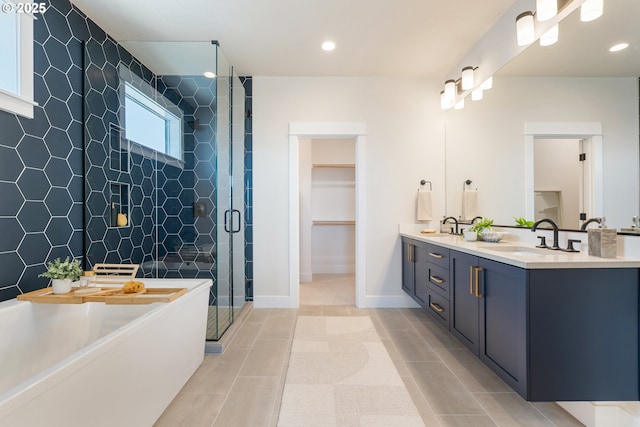 15174 SW 164th Ave Unit L12, Tigard, OR 97224 - bathroom with double vanity, a stall shower, a freestanding tub, a walk in closet, and baseboards