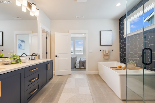 15174 SW 164th Ave Unit L12, Tigard, OR 97224 - bathroom with a tub to relax in, double vanity, healthy amount of natural light, tile patterned flooring, and recessed lighting