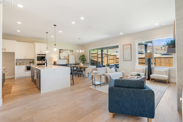 15174 SW 164th Ave Unit L12, Tigard, OR 97224 - living room featuring light wood-style flooring, recessed lighting, a chandelier, and baseboards