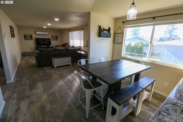 dining area with an AC wall unit and dark hardwood / wood-style flooring