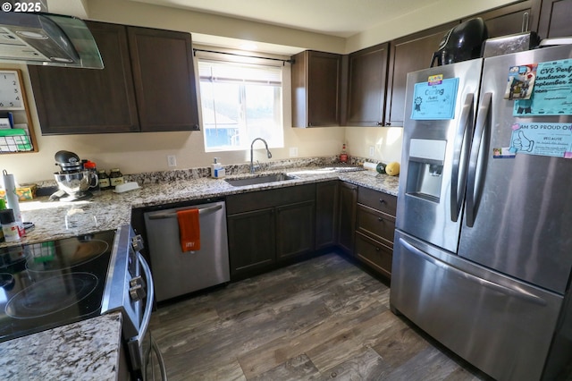 kitchen with dark brown cabinetry, dark hardwood / wood-style flooring, stainless steel appliances, sink, and light stone counters