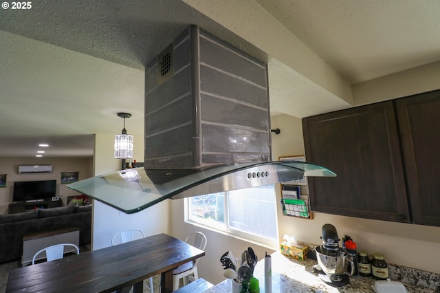 kitchen with dark brown cabinets, a textured ceiling, and a wall mounted air conditioner