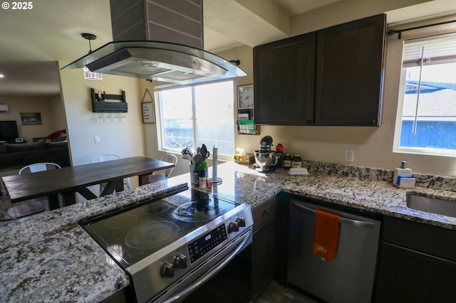 kitchen featuring island exhaust hood, appliances with stainless steel finishes, dark brown cabinets, and light stone countertops