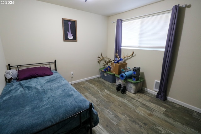 bedroom with dark hardwood / wood-style flooring