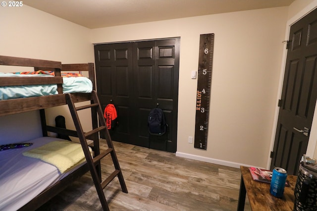 bedroom with wood-type flooring and a closet