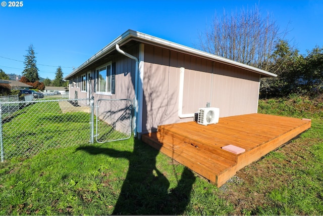 view of side of property featuring ac unit and a yard