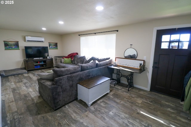 living room with a wall mounted AC and dark hardwood / wood-style floors