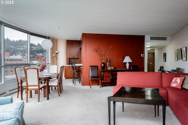 living area featuring light carpet, a textured ceiling, and visible vents