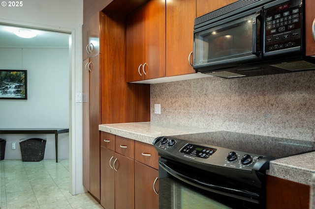 kitchen with tasteful backsplash, brown cabinets, light countertops, and black appliances