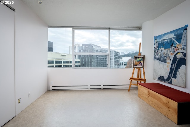 spare room with a baseboard heating unit, a view of city, finished concrete floors, and a textured ceiling