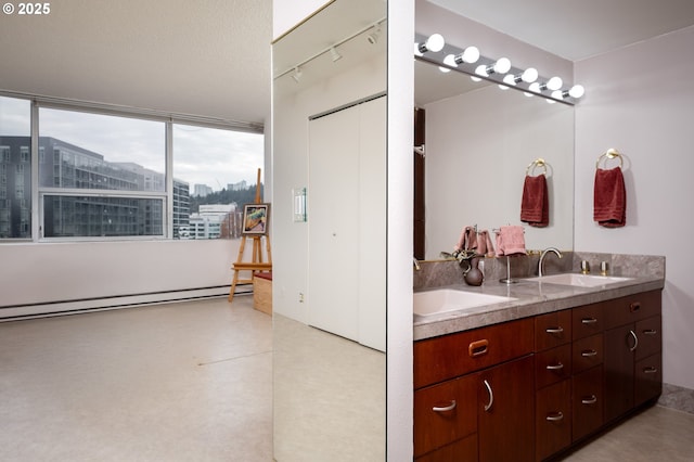 full bath featuring a view of city, double vanity, baseboard heating, and a sink