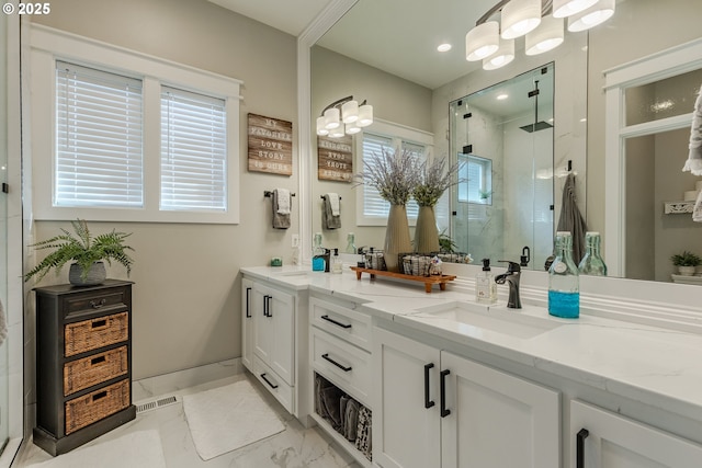 bathroom with a notable chandelier, vanity, and a shower with door