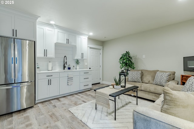 living room featuring sink and light hardwood / wood-style flooring