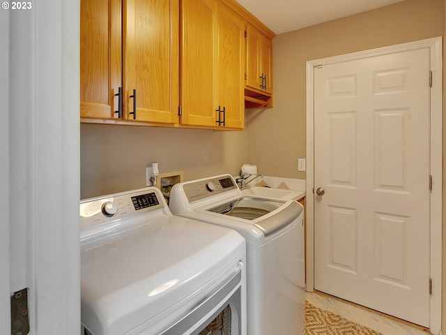 clothes washing area with cabinets, separate washer and dryer, light tile patterned flooring, and sink