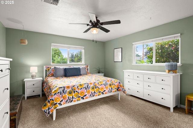 bedroom featuring carpet floors, a ceiling fan, and a textured ceiling