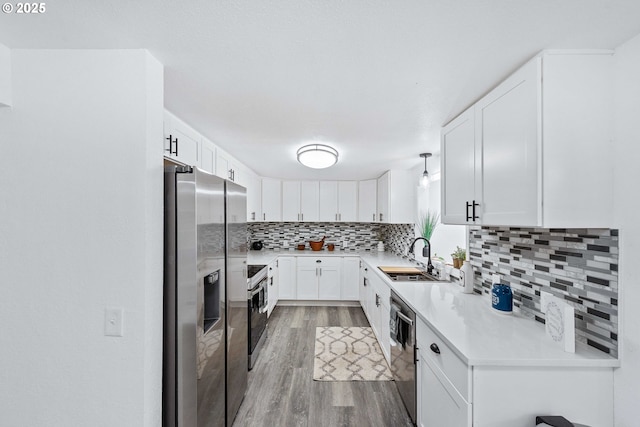 586 11th Ave, Coos Bay, OR 97420 - kitchen featuring a sink, light wood-style flooring, stainless steel appliances, tasteful backsplash, and light countertops