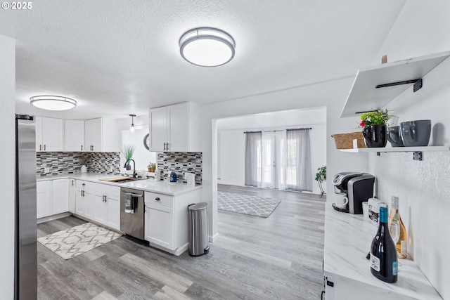 586 11th Ave, Coos Bay, OR 97420 - kitchen featuring stainless steel appliances, a sink, tasteful backsplash, white cabinets, and a textured ceiling