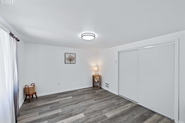 586 11th Ave, Coos Bay, OR 97420 - unfurnished bedroom with wood finished floors, a textured ceiling, a closet, and baseboards