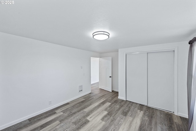 586 11th Ave, Coos Bay, OR 97420 - unfurnished bedroom featuring wood finished floors, baseboards, and a closet