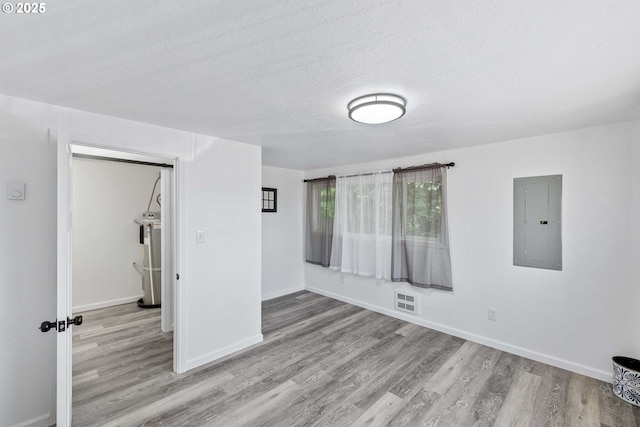586 11th Ave, Coos Bay, OR 97420 - spare room featuring electric panel, wood finished floors, baseboards, and a textured ceiling