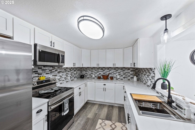 586 11th Ave, Coos Bay, OR 97420 - kitchen with appliances with stainless steel finishes, a sink, dark wood finished floors, light countertops, and decorative backsplash