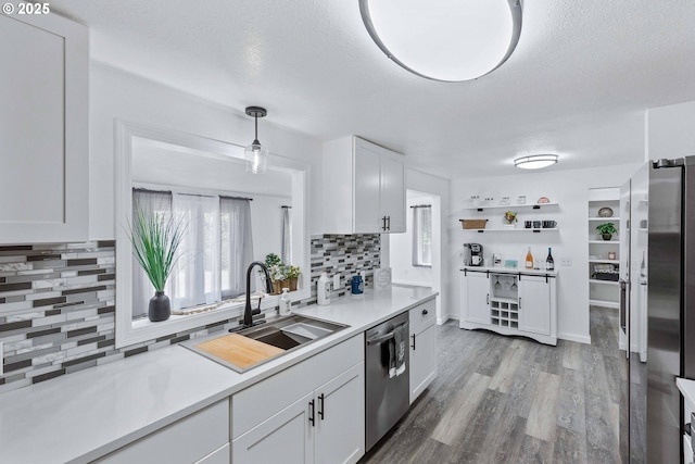 586 11th Ave, Coos Bay, OR 97420 - kitchen featuring appliances with stainless steel finishes, a sink, backsplash, white cabinetry, and a textured ceiling