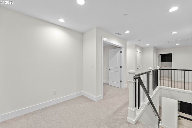 hall featuring visible vents, baseboards, light colored carpet, an upstairs landing, and recessed lighting