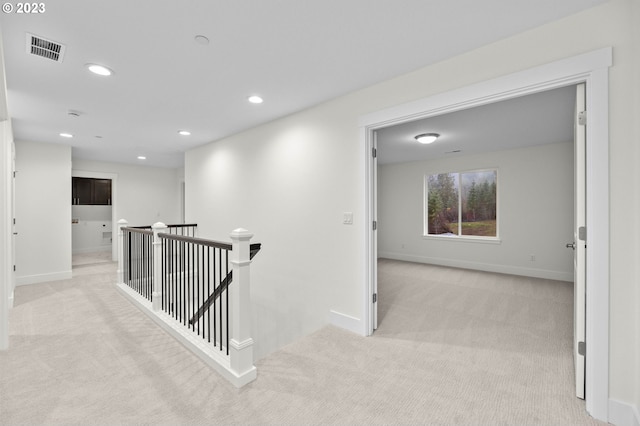 hall with light carpet, visible vents, baseboards, an upstairs landing, and recessed lighting