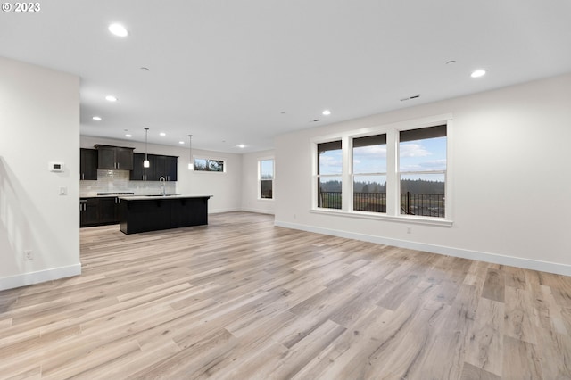 living area with baseboards, recessed lighting, visible vents, and light wood-style floors