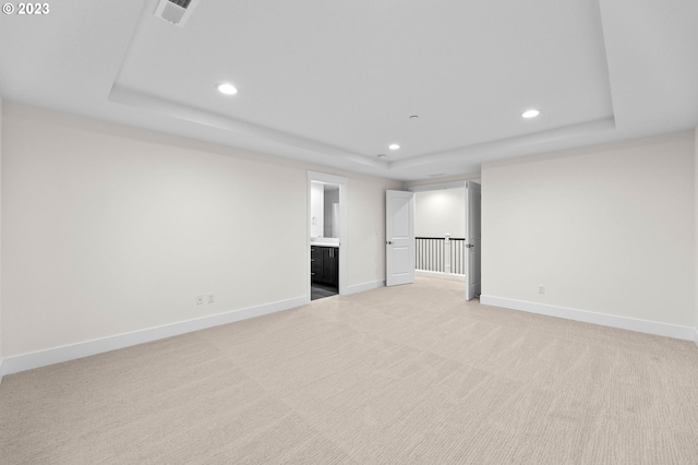 interior space with a raised ceiling, visible vents, and baseboards