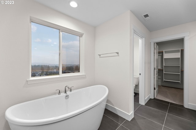 full bathroom with a soaking tub, visible vents, toilet, tile patterned flooring, and baseboards