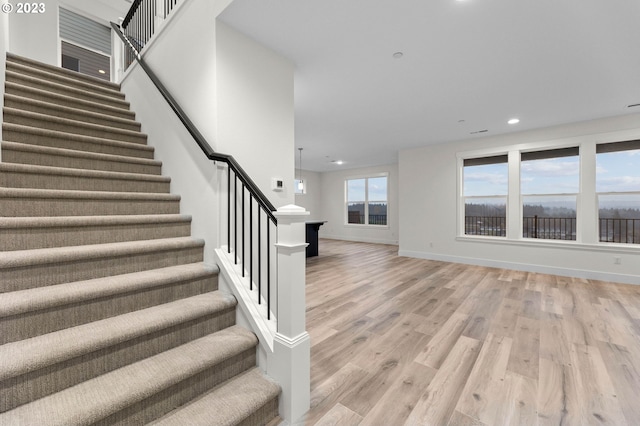 staircase featuring recessed lighting, wood finished floors, and baseboards