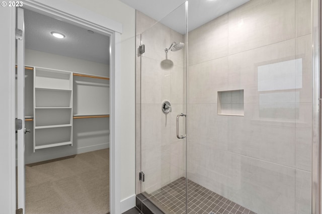 bathroom featuring a stall shower and a walk in closet