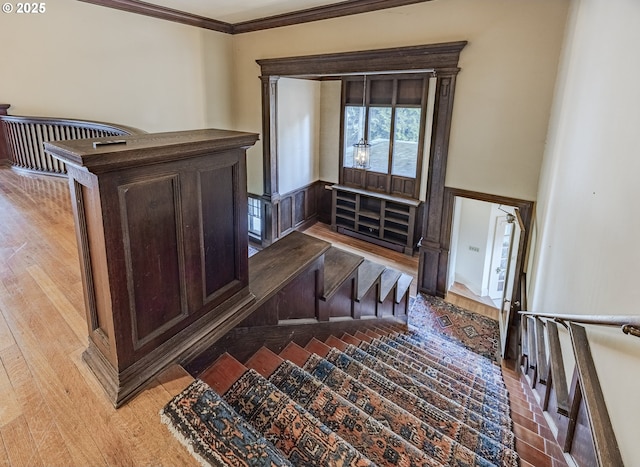 stairway featuring crown molding and hardwood / wood-style floors