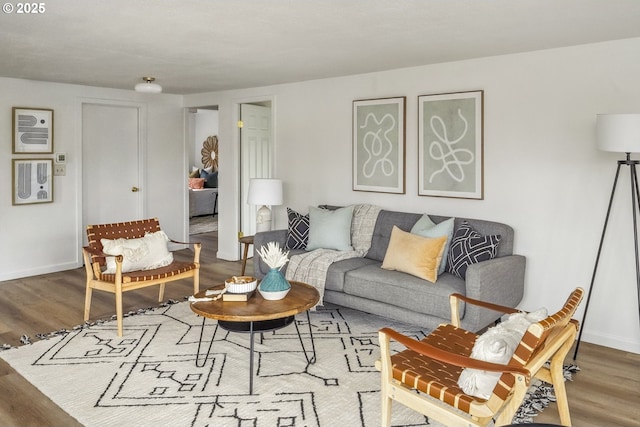 living area with baseboards and wood finished floors