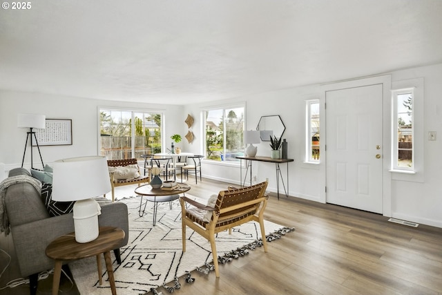 living area featuring light wood-style flooring, baseboards, and visible vents