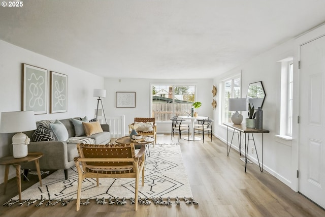 living area with baseboards and light wood finished floors