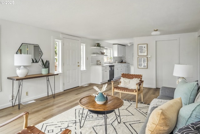 living room featuring a wealth of natural light, baseboards, and light wood-style floors