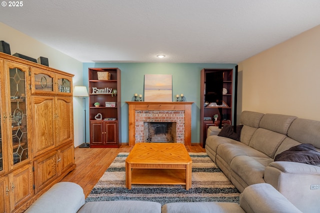 living room featuring light wood-type flooring and a fireplace