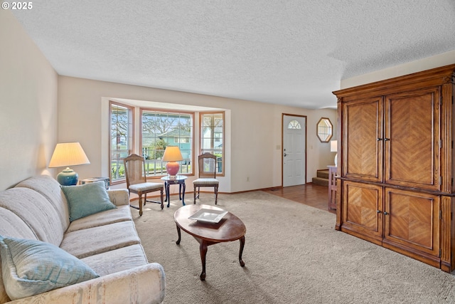 living room with baseboards, carpet, stairs, and a textured ceiling