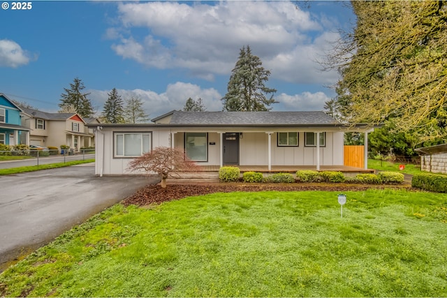 ranch-style house featuring board and batten siding, a front yard, and covered porch