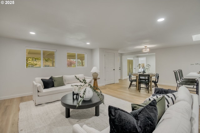 living area with baseboards, light wood-style floors, and recessed lighting