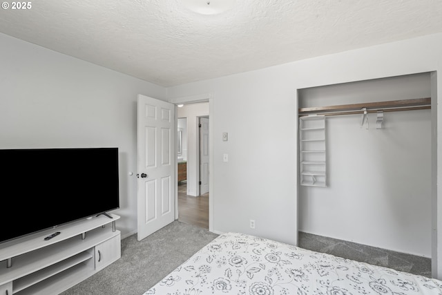 bedroom featuring a closet, light colored carpet, and a textured ceiling