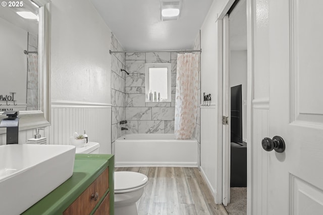 full bathroom with shower / bathtub combination with curtain, vanity, wood-type flooring, and toilet