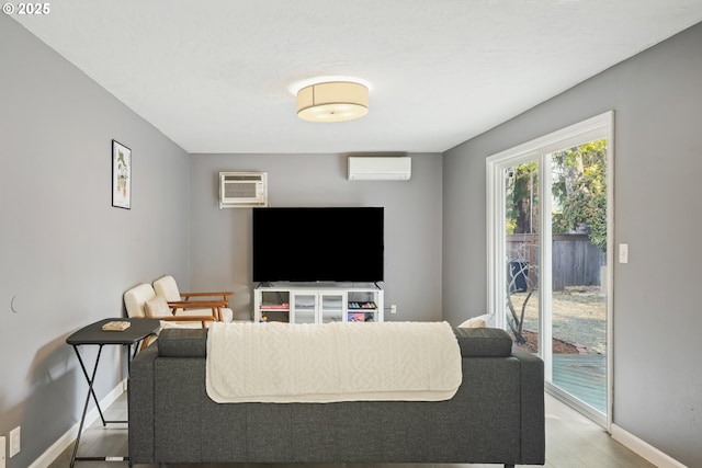 living room featuring a wall mounted air conditioner and light wood-type flooring