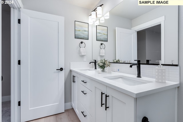 bathroom featuring vanity, backsplash, and hardwood / wood-style floors