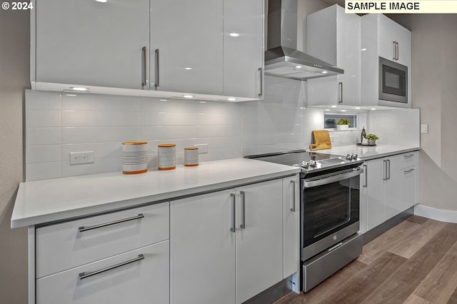 16755 SE Shimmering Leaf St, Happy Valley, OR 97086 - kitchen with stainless steel electric stove, dark wood-style floors, modern cabinets, and wall chimney exhaust hood