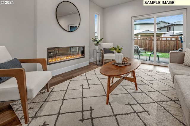 16755 SE Shimmering Leaf St, Happy Valley, OR 97086 - living area featuring plenty of natural light, baseboards, a glass covered fireplace, and wood finished floors