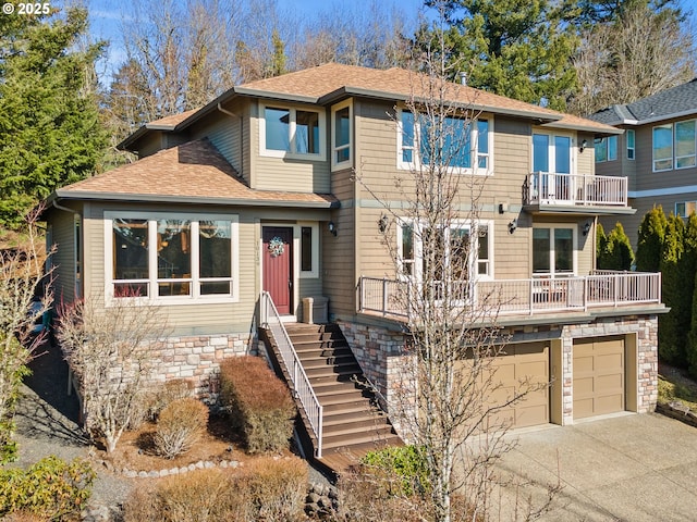 view of front of property featuring driveway, roof with shingles, and an attached garage