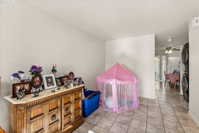1720 17th St, Springfield, OR 97477 - game room with stacked washing machine and dryer, a textured ceiling, ceiling fan, and light tile patterned floors